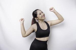 une jeune femme asiatique sportive avec une expression heureuse et réussie portant des vêtements de sport isolés sur fond blanc photo