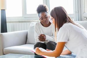 médecin travaillant au bureau et écoutant le patient, elle explique ses symptômes, ses soins de santé et son concept d'assistance médecin sérieux avec presse-papiers et patient à l'hôpital. photo