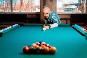 l'homme se prépare à briser la pyramide de boules de billard sur la table photo