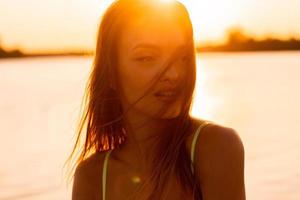 jeune femme sexuelle dans la mer au coucher du soleil chaud photo