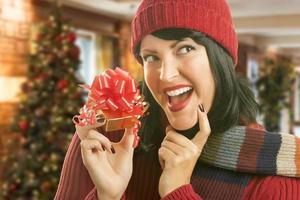 femme tenant un cadeau emballé dans un décor de noël photo