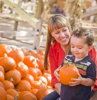 famille métisse heureuse au champ de citrouilles photo