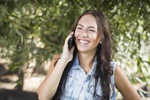 jeune femme métisse parlant au téléphone portable à l'extérieur photo