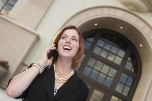 femme d'affaires heureuse sur téléphone portable devant l'hôtel de ville photo