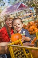 famille métisse heureuse au champ de citrouilles photo