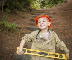 adorable enfant garçon avec niveau jouant bricoleur à l'extérieur photo