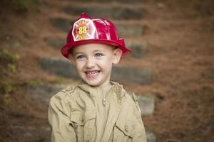 adorable enfant garçon avec chapeau de pompier jouant dehors photo