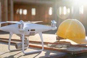 quadricoptère drone à côté d'un casque de casque sur un chantier de construction photo