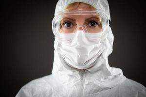 travailleuse médicale portant un masque de protection et un équipement sur fond sombre photo