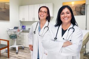 femmes médecins hispaniques et caucasiennes debout au bureau photo