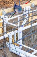 tuyaux de plomberie en pvc nouvellement installés et configuration des barres d'armature en acier sur le chantier de construction photo