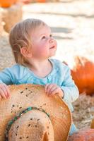 adorable petite fille avec chapeau de cow-boy dans un cadre rustique au champ de citrouilles. photo