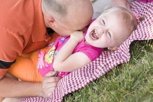 papa aimant chatouille sa fille dans le parc photo