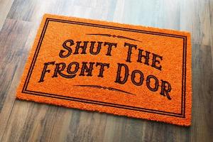 fermez la porte d'entrée tapis de bienvenue orange halloween sur fond de plancher en bois photo