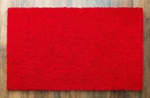 Tapis de bienvenue rouge vierge sur fond de plancher de bois prêt pour votre propre texte photo