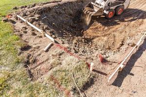 petit bulldozer creusant dans la cour pour l'installation de la piscine photo