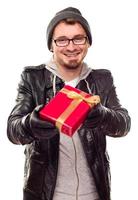 jeune homme chaudement habillé remettant un cadeau emballé photo