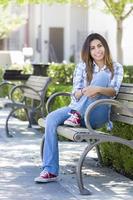 portrait d'une étudiante de race mixte sur un banc du campus de l'école photo