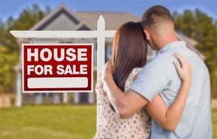 à vendre enseigne immobilière, couple militaire regardant la maison photo