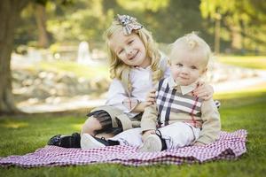 douce petite fille embrasse son petit frère au parc photo