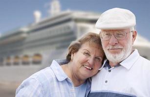 couple de personnes âgées à terre devant un bateau de croisière photo