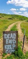 Dead End garder hors signe sur grillage au chemin de terre photo