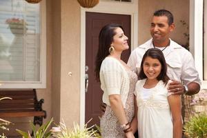 petite famille hispanique heureuse devant leur maison photo
