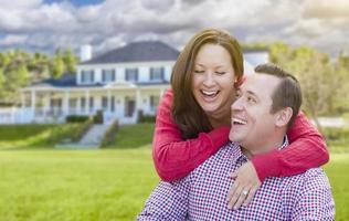couple heureux à l'extérieur devant une belle maison photo