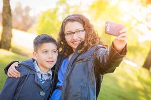 frère et soeur hispaniques prenant le selfie avec le téléphone portable photo