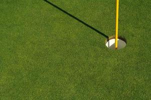 vert de golf et drapeau luxuriants et fraîchement tondu photo