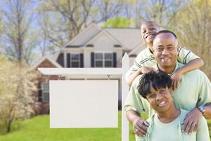 famille afro-américaine devant une enseigne et une maison vierges photo