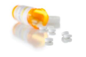 bouteille de prescription de médecine non exclusive et pilules renversées isolées sur blanc photo