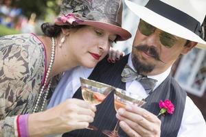 couple mixte habillé à la mode des années 1920 en sirotant du champagne photo