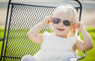 Jolie petite fille ludique portant des lunettes de soleil à l'extérieur du parc photo
