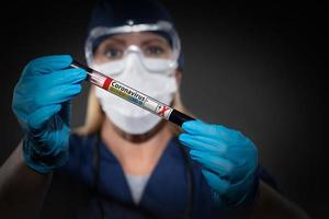 une travailleuse de laboratoire tient un tube à essai de sang étiqueté coronavirus covid-19 photo