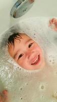 heureux mignon jeune garçon chinois et caucasien s'amusant à l'heure du bain photo