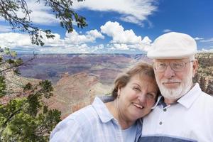 heureux couple de personnes âgées posant au bord du grand canyon photo