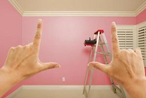 Mains encadrant l'intérieur du mur peint en rose photo