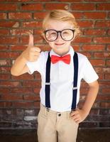 mignon jeune garçon caucasien avec les pouces vers le haut portant des lunettes et rouge, blanc et bleu photo