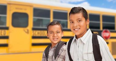 jeunes garçons hispaniques marchant près du bus scolaire photo