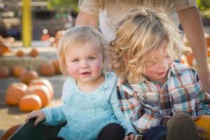 jeune famille profite d'une journée au champ de citrouilles photo