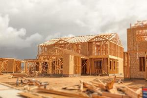 Résumé de l'ossature de la maison en bois sur le chantier de construction avec des nuages orageux derrière photo