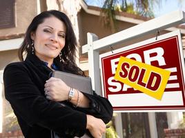femme hispanique agent immobilier, vendu à vendre enseigne immobilière et maison photo