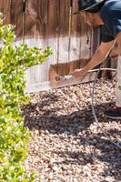 peintre professionnel pulvérisant une clôture de jardin avec tache photo