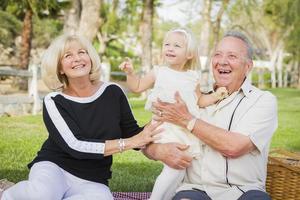 petite-fille et grands-parents affectueux jouant au parc photo