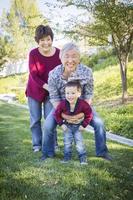 grands-parents chinois s'amusant avec leur petit-fils métis à l'extérieur photo