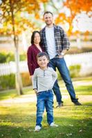 portrait en plein air de joyeux parents et enfants métis chinois et caucasiens. photo