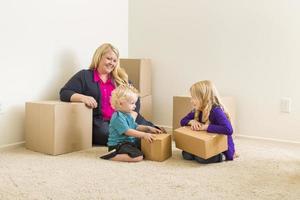 jeune famille dans une pièce vide avec des cartons de déménagement photo