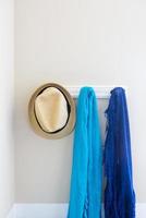 mur dans la maison avec chapeau et écharpes suspendus sur des crochets de portemanteau abstrait photo