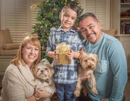 jeune famille métisse devant l'arbre de noël photo